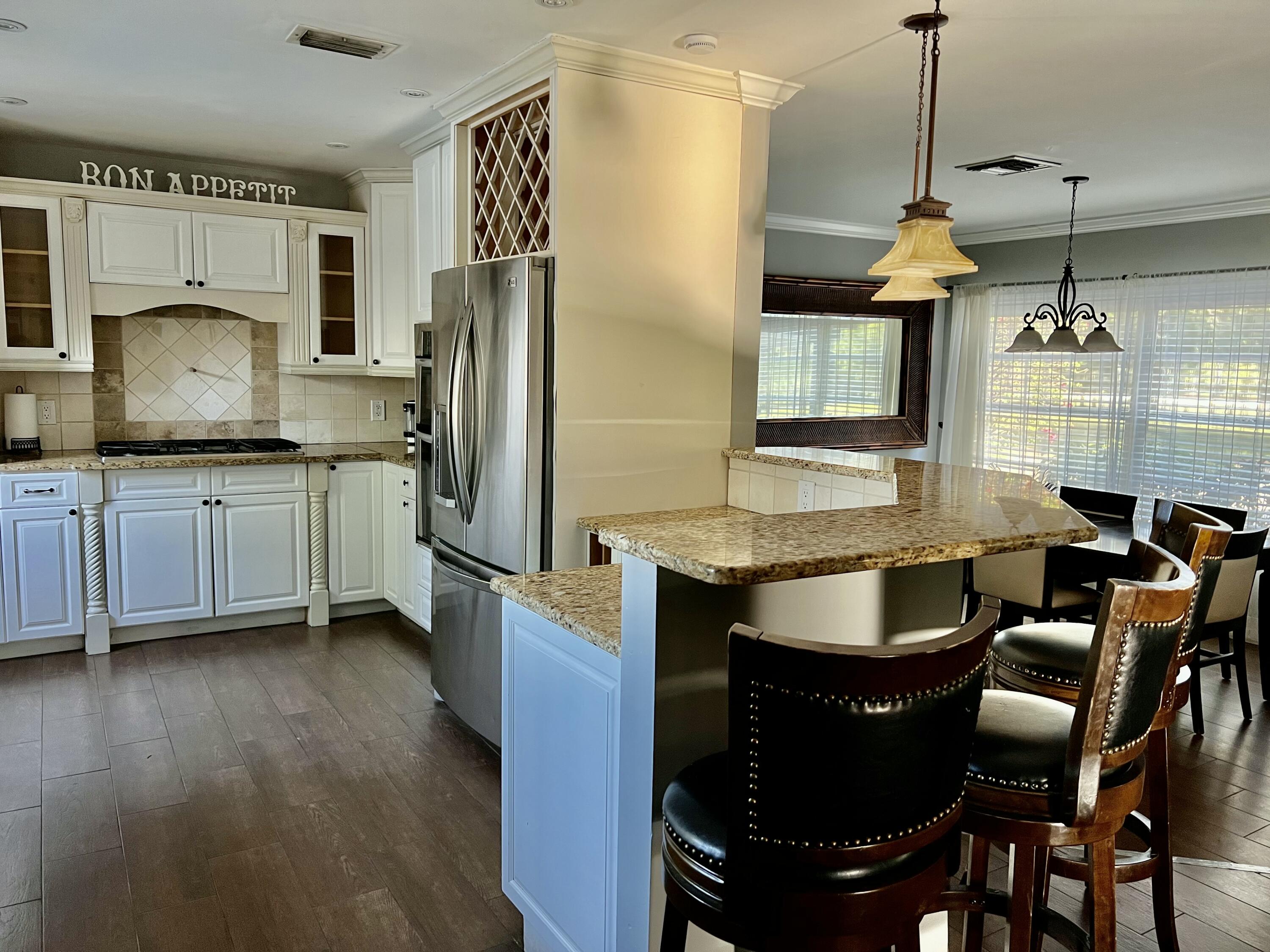 16163 16097 Rustic Road Wellington, FL 33470 - Photo 3 of 36 a kitchen with granite countertop a sink stainless steel appliances and cabinets