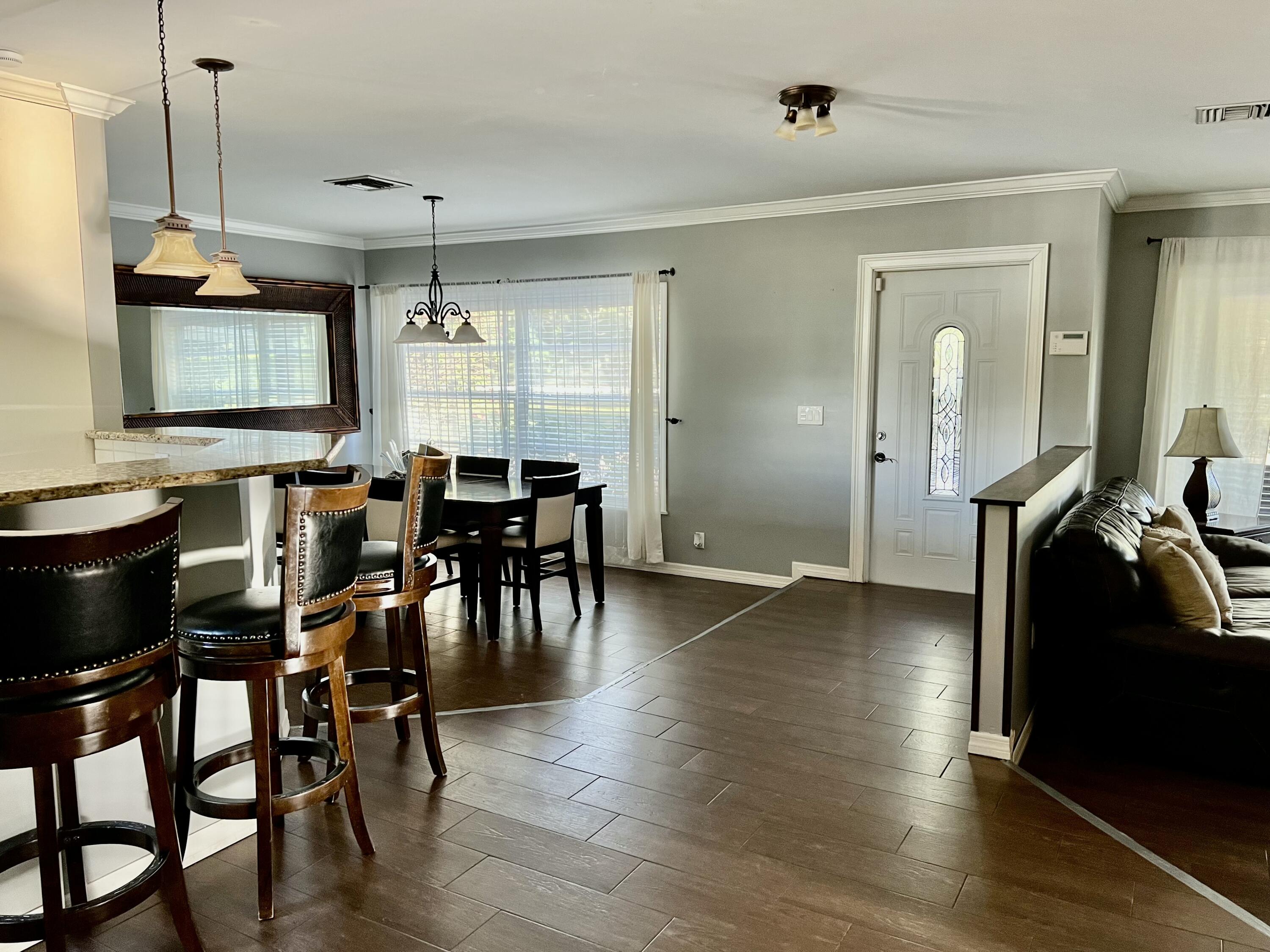 16163 16097 Rustic Road Wellington, FL 33470 - Photo 7 of 36 a view of a dining room with furniture window and wooden floor