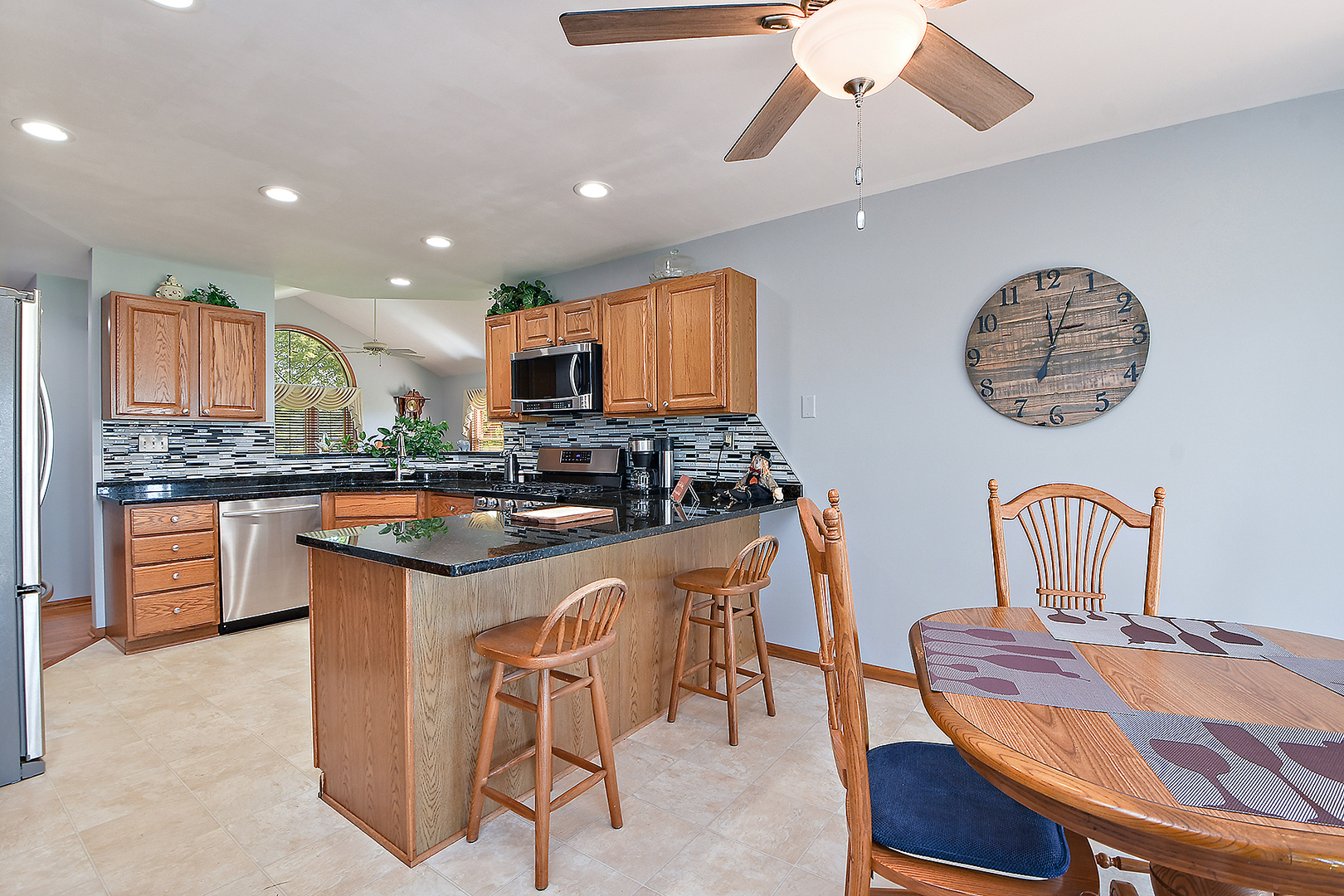 32220 South Cedar Road Manhattan, IL 60442 - Photo 12 of 46 a kitchen with stainless steel appliances kitchen island granite countertop a stove a sink a dining table and chairs