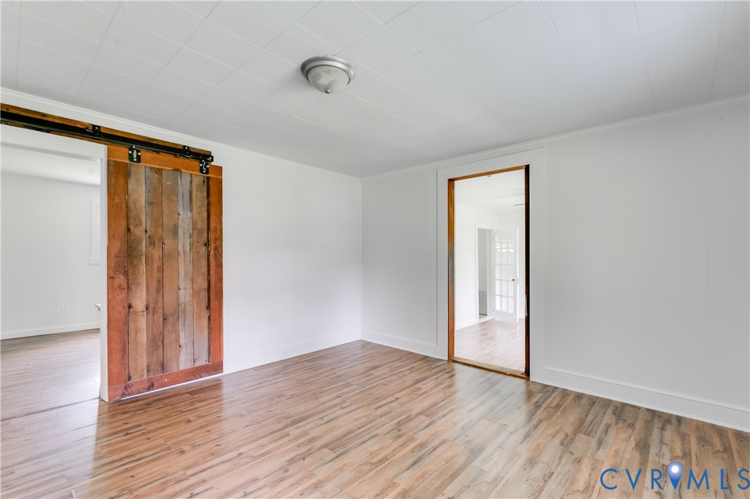 Interior room featuring wood-finish flooring, whit