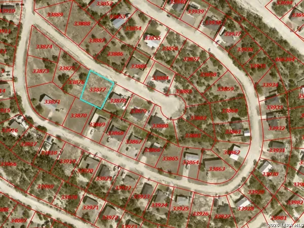 a view of a dry yard with wooden fence