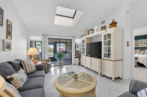 a living room with furniture a flat screen tv and a large window