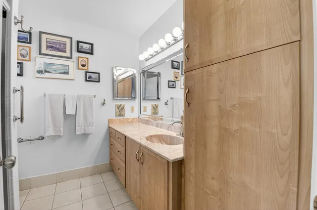 a bathroom with a granite countertop sink a mirror and shower