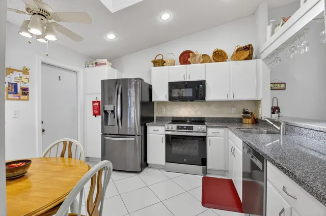 a kitchen with stainless steel appliances granite countertop a sink a stove a refrigerator and island