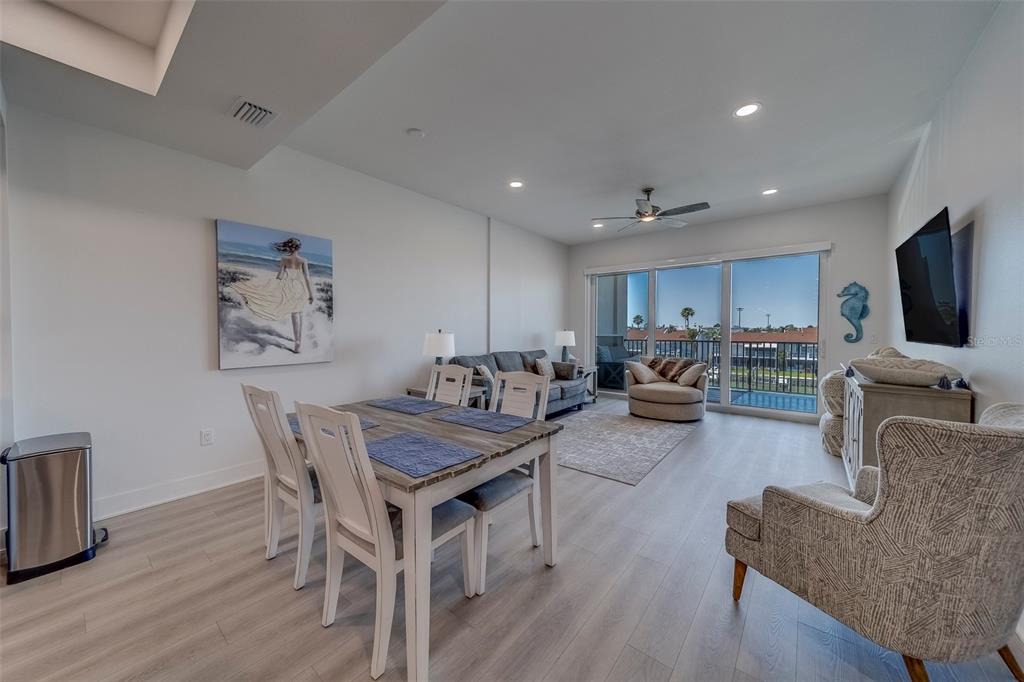400 150th Avenue, Unit 301 Madeira Beach, FL 33708 - Photo 11 of 66 a living room with furniture a flat screen tv and kitchen view