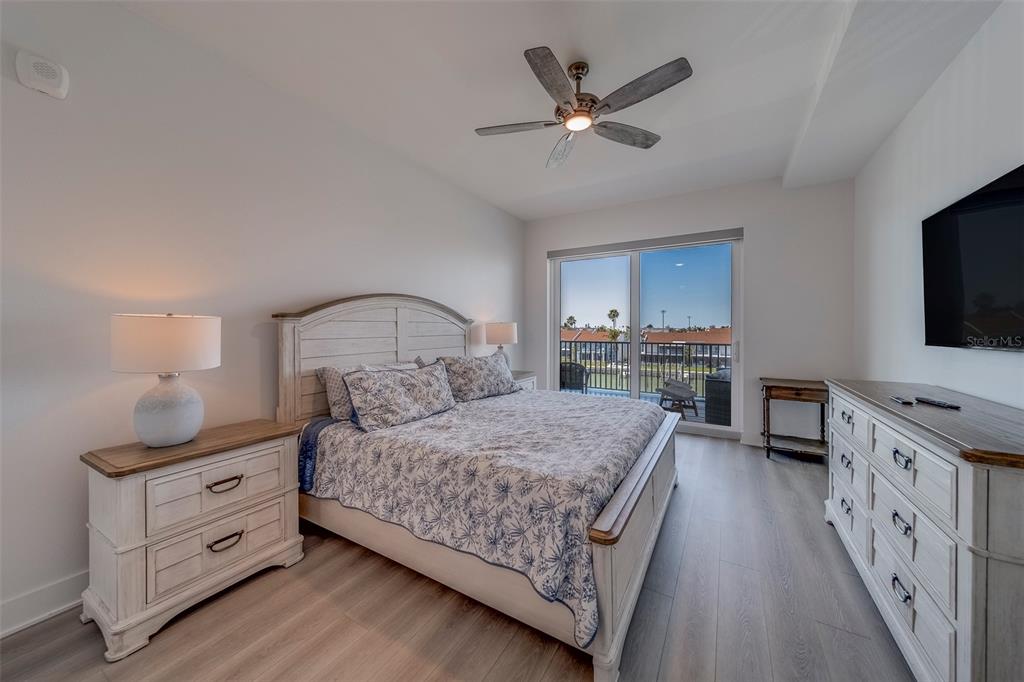 400 150th Avenue, Unit 301 Madeira Beach, FL 33708 - Photo 17 of 66 a bedroom with a large bed and a flat tv screen on dresser