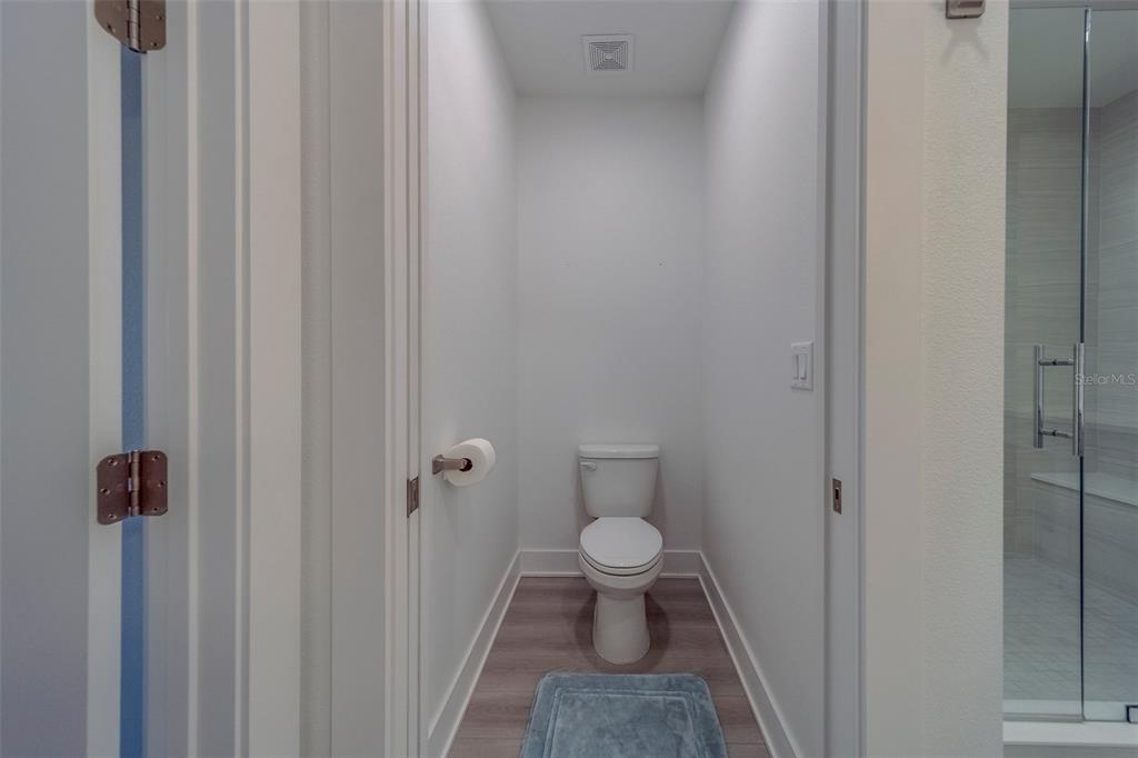 400 150th Avenue, Unit 301 Madeira Beach, FL 33708 - Photo 24 of 66 a bathroom with a granite countertop toilet and a shower