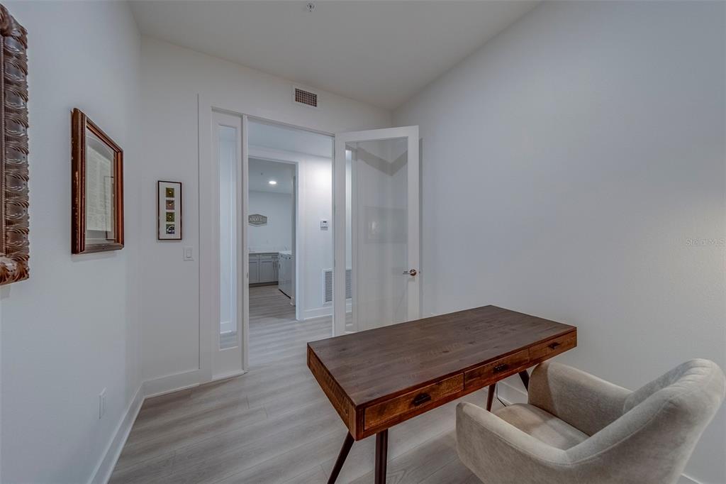 400 150th Avenue, Unit 301 Madeira Beach, FL 33708 - Photo 28 of 66 a view of a hallway with wooden floor and a bathroom