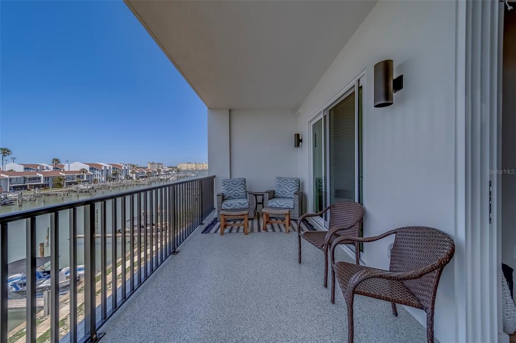 400 150th Avenue, Unit 301 Madeira Beach, FL 33708 - Photo 30 of 66 a balcony with chairs and a potted plant