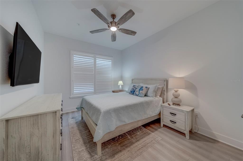 400 150th Avenue, Unit 301 Madeira Beach, FL 33708 - Photo 36 of 66 a bedroom with a bed and a flat screen tv