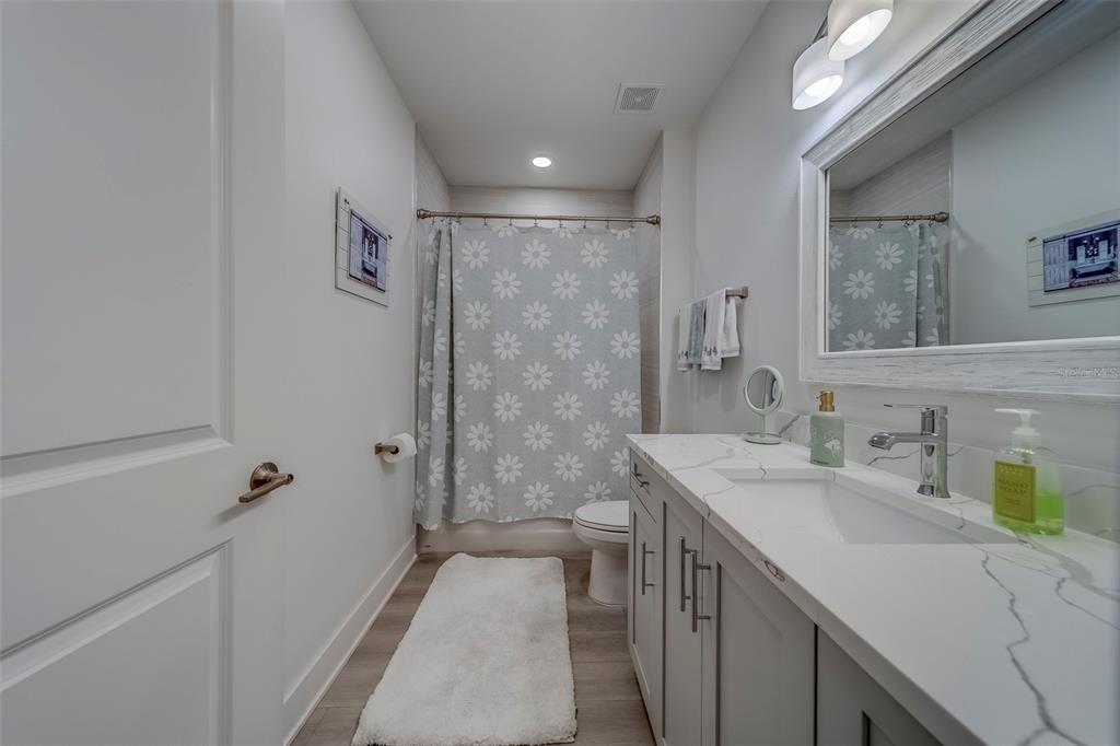 400 150th Avenue, Unit 301 Madeira Beach, FL 33708 - Photo 40 of 66 a bathroom with a sink a toilet a shower and a mirror
