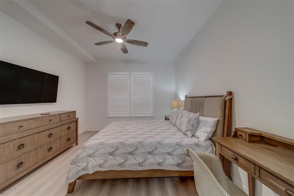 400 150th Avenue, Unit 301 Madeira Beach, FL 33708 - Photo 43 of 66 a bedroom with a bed and a flat screen tv