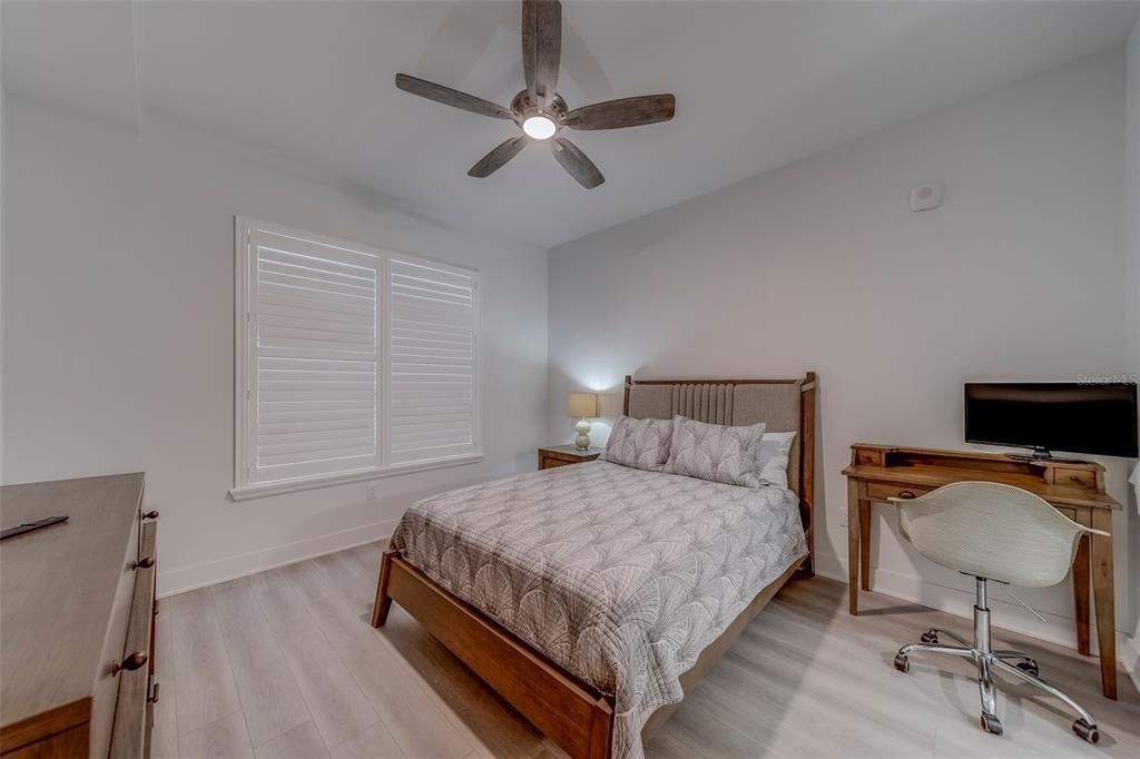 400 150th Avenue, Unit 301 Madeira Beach, FL 33708 - Photo 44 of 66 a bedroom with a bed a chair and a chandelier