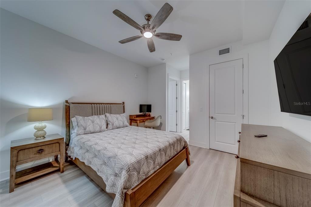 400 150th Avenue, Unit 301 Madeira Beach, FL 33708 - Photo 45 of 66 a bedroom with a bed and a flat tv screen on dresser
