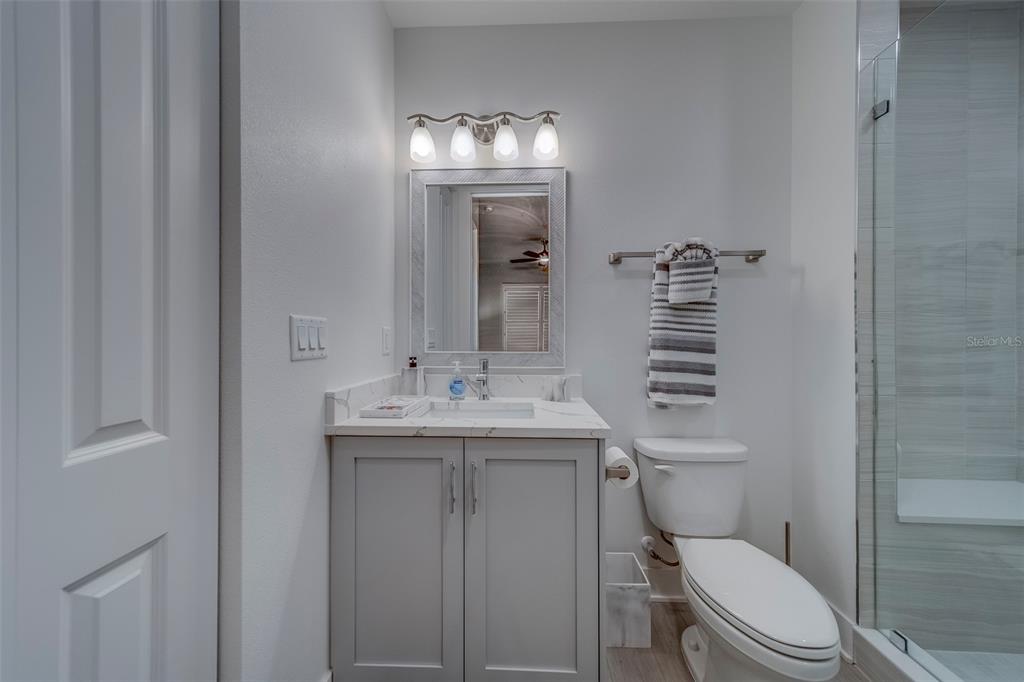 400 150th Avenue, Unit 301 Madeira Beach, FL 33708 - Photo 46 of 66 a bathroom with a toilet a sink and mirror
