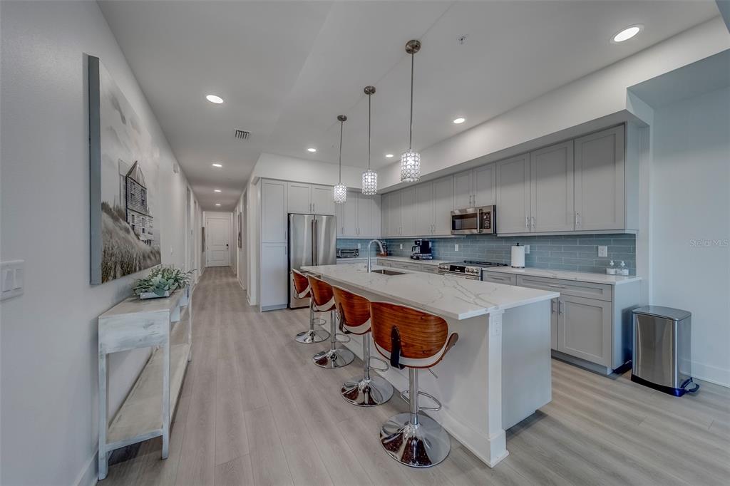 400 150th Avenue, Unit 301 Madeira Beach, FL 33708 - Photo 5 of 66 a kitchen with stainless steel appliances granite countertop a sink a stove and a wooden floors