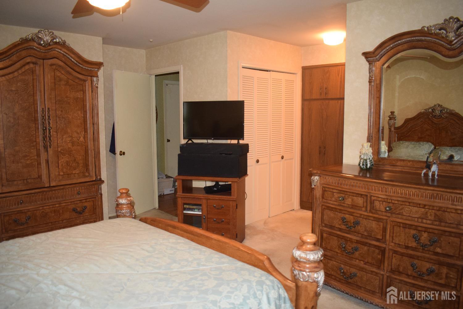 15 Cutter Avenue Edison, NJ 08820 - Photo 9 of 32 a bedroom with a bed and a flat tv screen on dresser