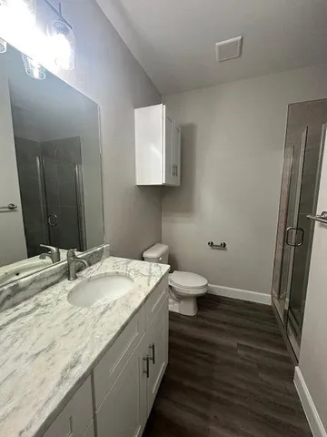 a bathroom with a granite countertop sink toilet and shower