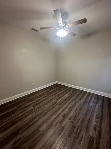 a view of a room with wooden floor and chandelier fan