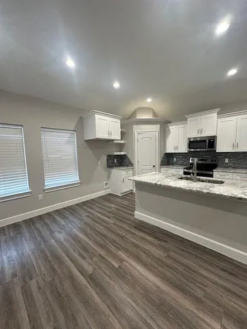 a view of kitchen with sink microwave and cabinets