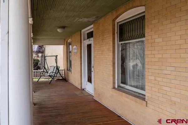 a view of a porch with a table and chairs and wooden floor