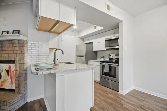 a kitchen with stainless steel appliances granite countertop a stove and a sink