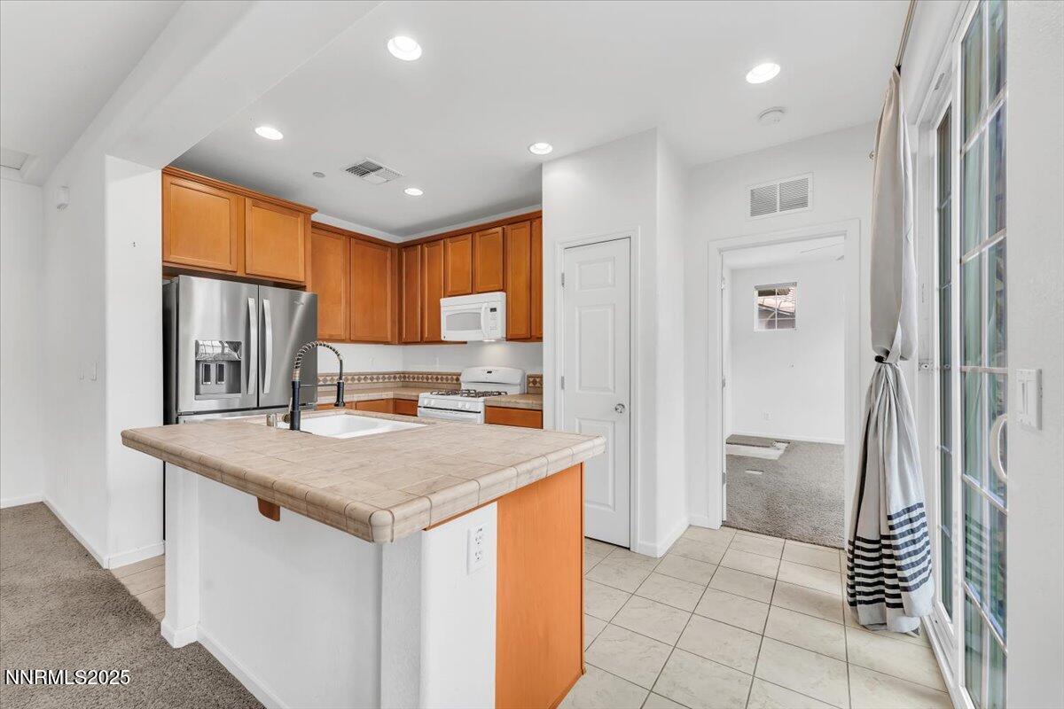1932 Wind Ranch Road, Unit C Reno, NV 89521 - Photo 17 of 29 a kitchen with a sink a refrigerator and a stove top oven