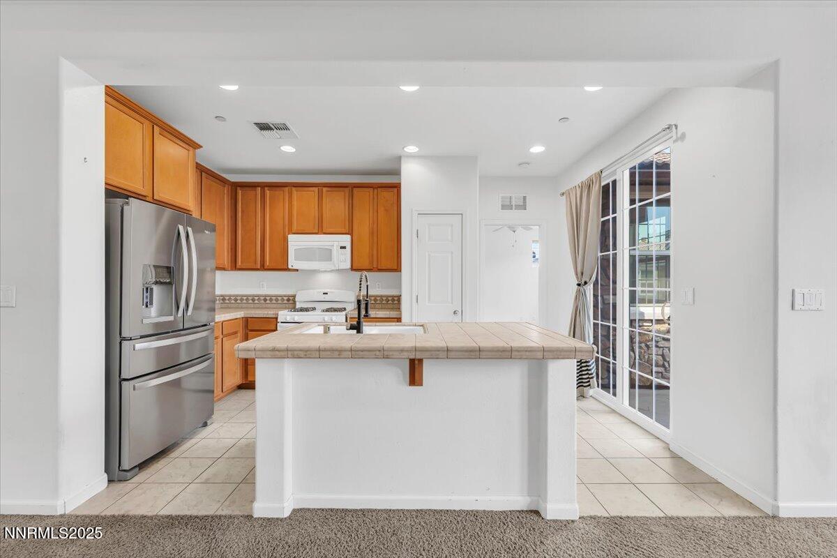 1932 Wind Ranch Road, Unit C Reno, NV 89521 - Photo 18 of 29 a kitchen with stainless steel appliances granite countertop a refrigerator a sink dishwasher a stove and a refrigerator with wooden floor