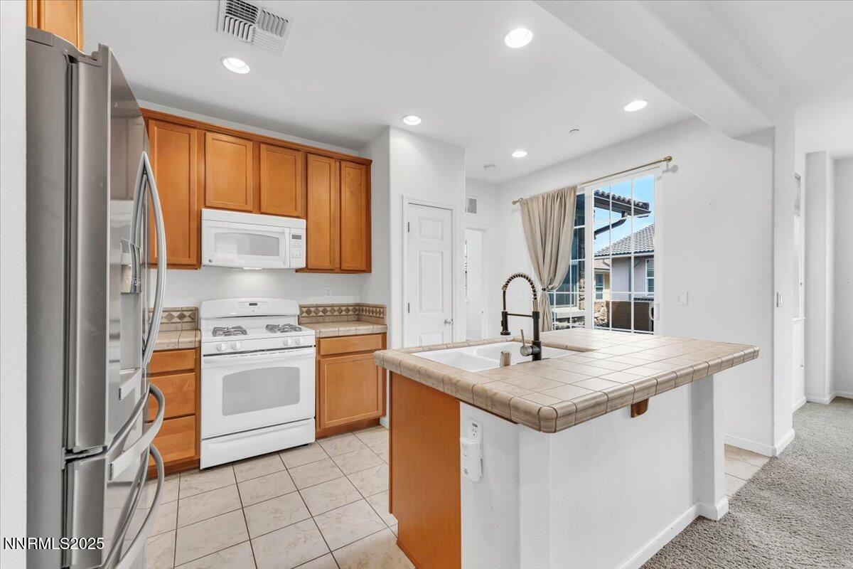 1932 Wind Ranch Road, Unit C Reno, NV 89521 - Photo 19 of 29 a kitchen that has a sink a stove and a refrigerator