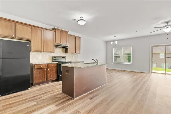 a kitchen with a refrigerator stove top oven and cabinets