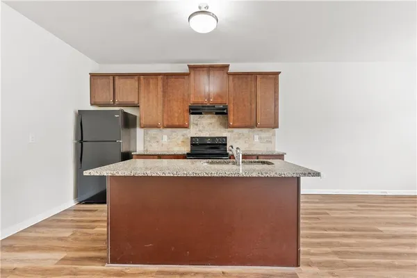 a kitchen with kitchen island granite countertop cabinets and refrigerator