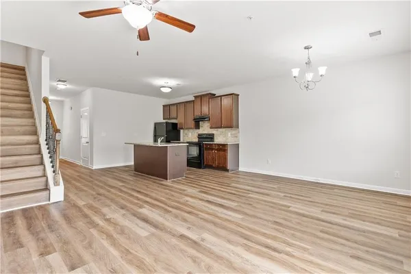 a view of empty room with wooden floor and ceiling fan