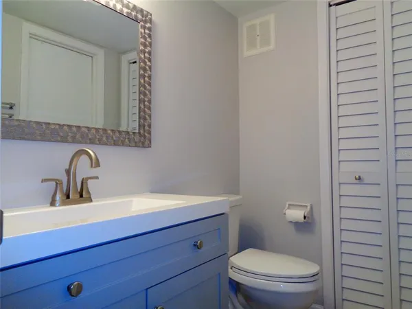 a bathroom with a toilet a sink a vanity and mirror