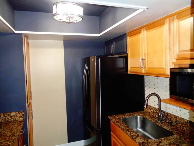 a kitchen with a refrigerator and a sink