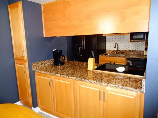 a kitchen with granite countertop a sink and a stove top oven