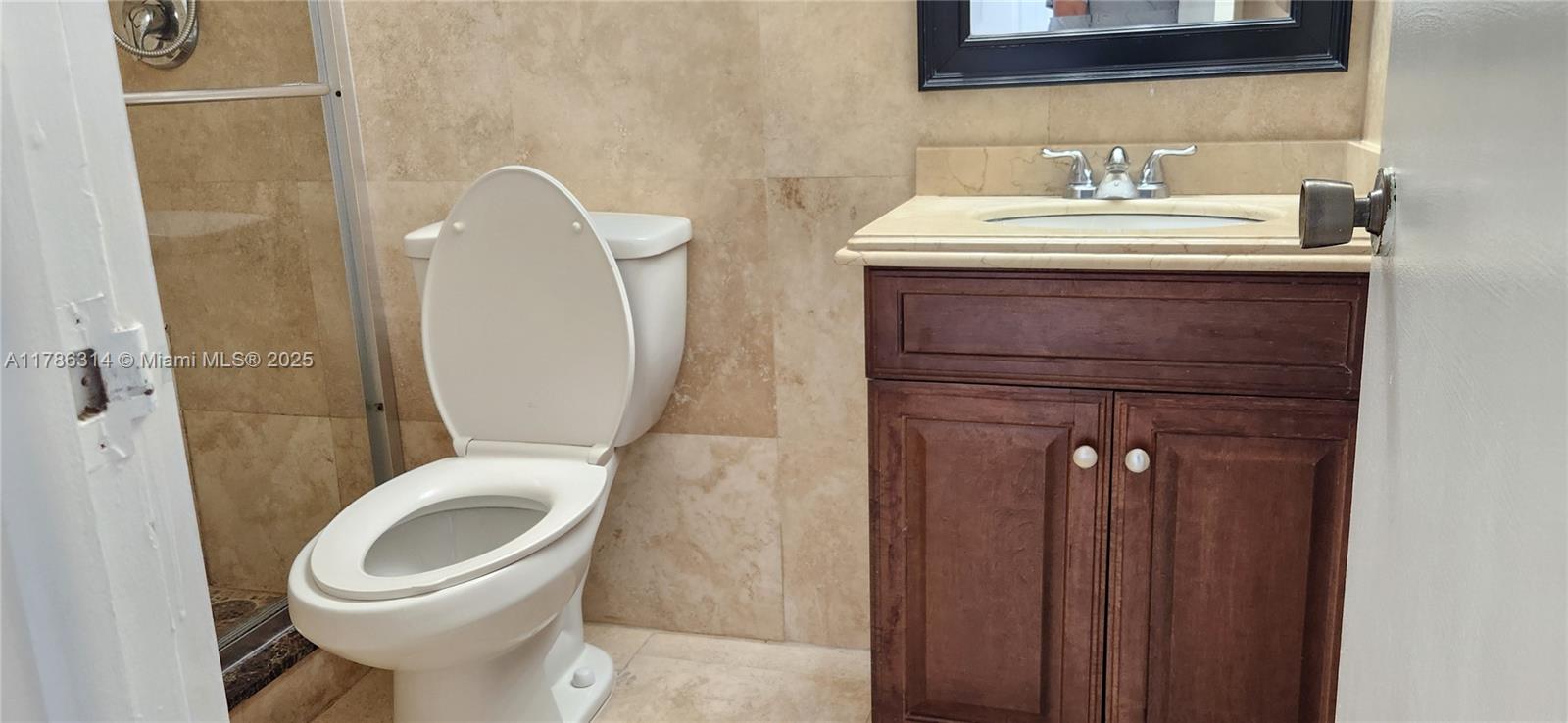 14195 Southwest 87th Street, Unit B306 Miami, FL 33183 - Photo 11 of 13 a bathroom with a toilet sink and mirror