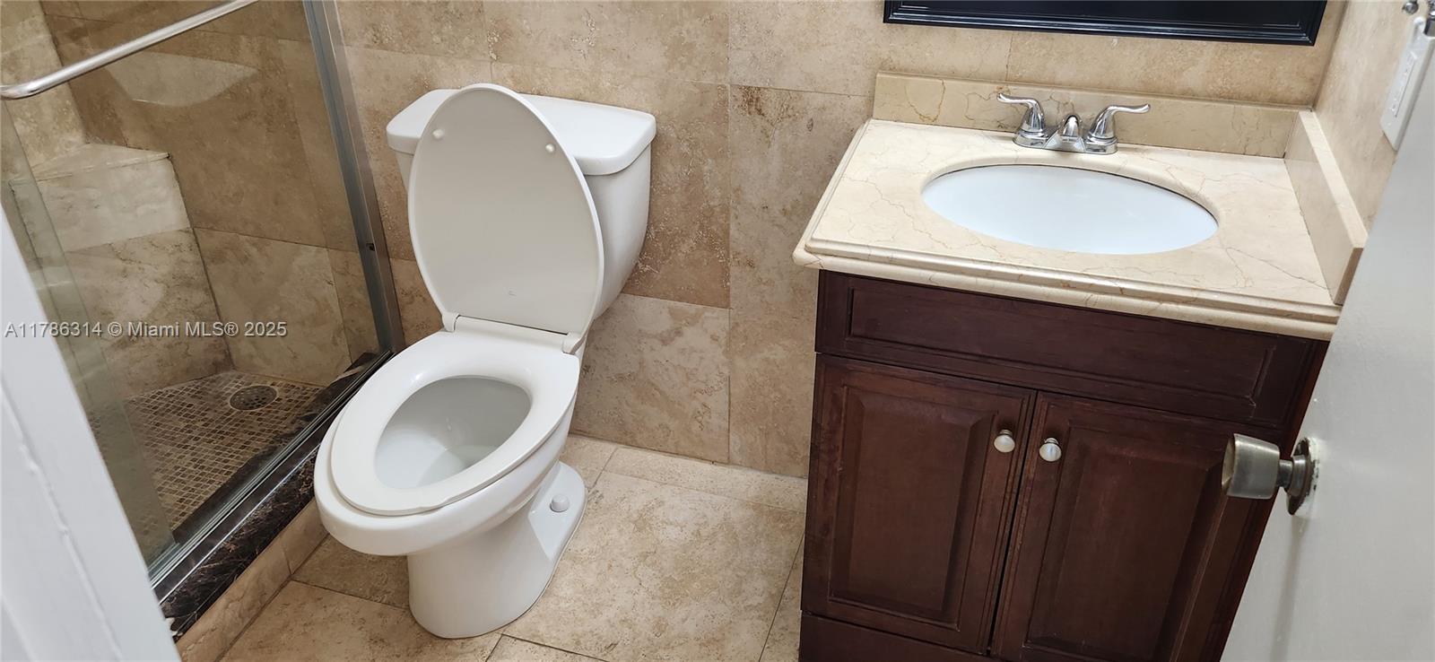 14195 Southwest 87th Street, Unit B306 Miami, FL 33183 - Photo 12 of 13 a bathroom with a sink a toilet and a mirror