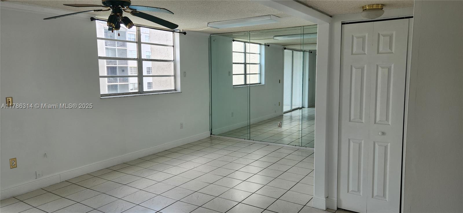 14195 Southwest 87th Street, Unit B306 Miami, FL 33183 - Photo 5 of 13 an empty room that has a window in it