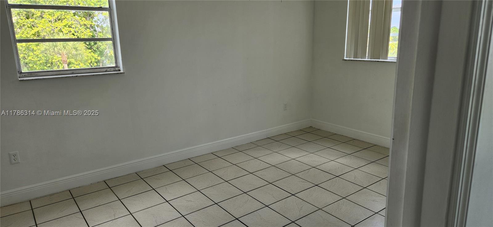 14195 Southwest 87th Street, Unit B306 Miami, FL 33183 - Photo 6 of 13 an empty room with windows
