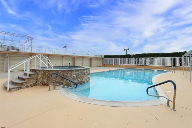 a living room with stainless steel appliances kitchen island granite countertop a sink and cabinets