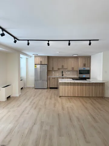 a kitchen with stainless steel appliances granite countertop a refrigerator and a stove top oven