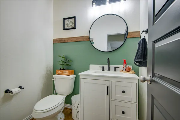 a bathroom with a sink mirror toilet and vanity