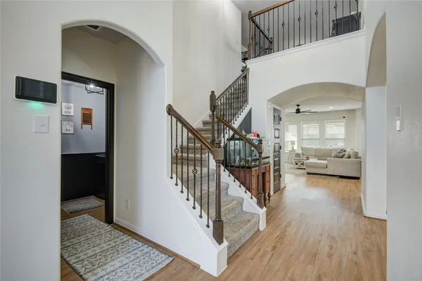 a view of front door with hallway and wooden floor