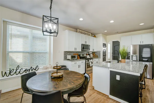 a kitchen with sink a refrigerator and chairs