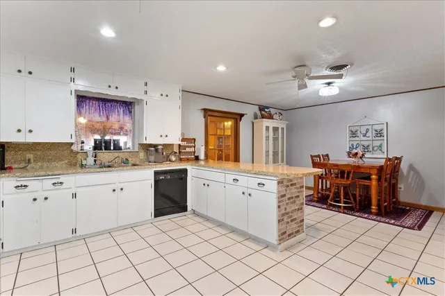a kitchen with cabinets and chairs