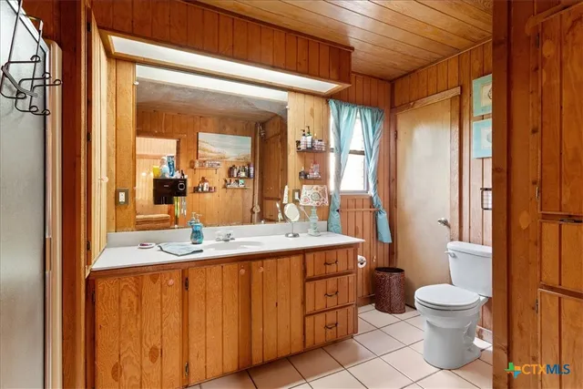 a bathroom with a granite countertop sink toilet a mirror and shower