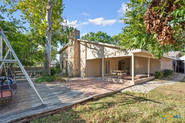 a backyard of a house with barbeque oven table and chairs