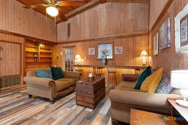 a living room with furniture a ceiling fan and a window