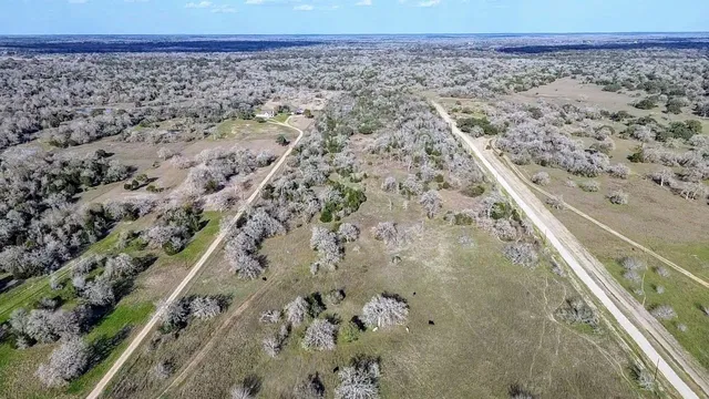a view of a dry yard with wooden floor and a covered with snow in the background