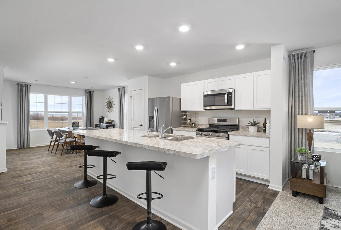 1479 Yosemite Way Pingree Grove, IL 60140 - Photo 17 of 27 a kitchen with a dining table chairs refrigerator and microwave